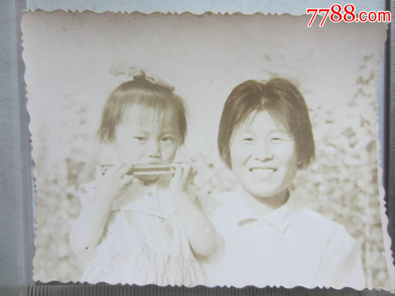 女子抱吹口琴小女孩合影(老照片)