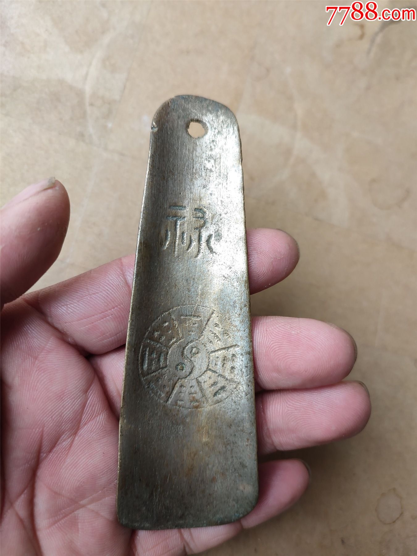 刻花刻字的铜器鞋拔子,中间有一条两厘米的裂纹,如图所示