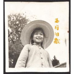 六七十年代老照片，佩戴草帽，有着灿烂笑容的小姑娘